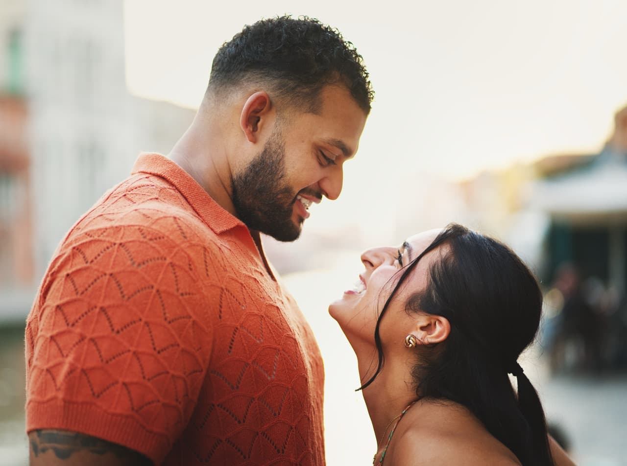 Joyful couple looking at each other in Venice